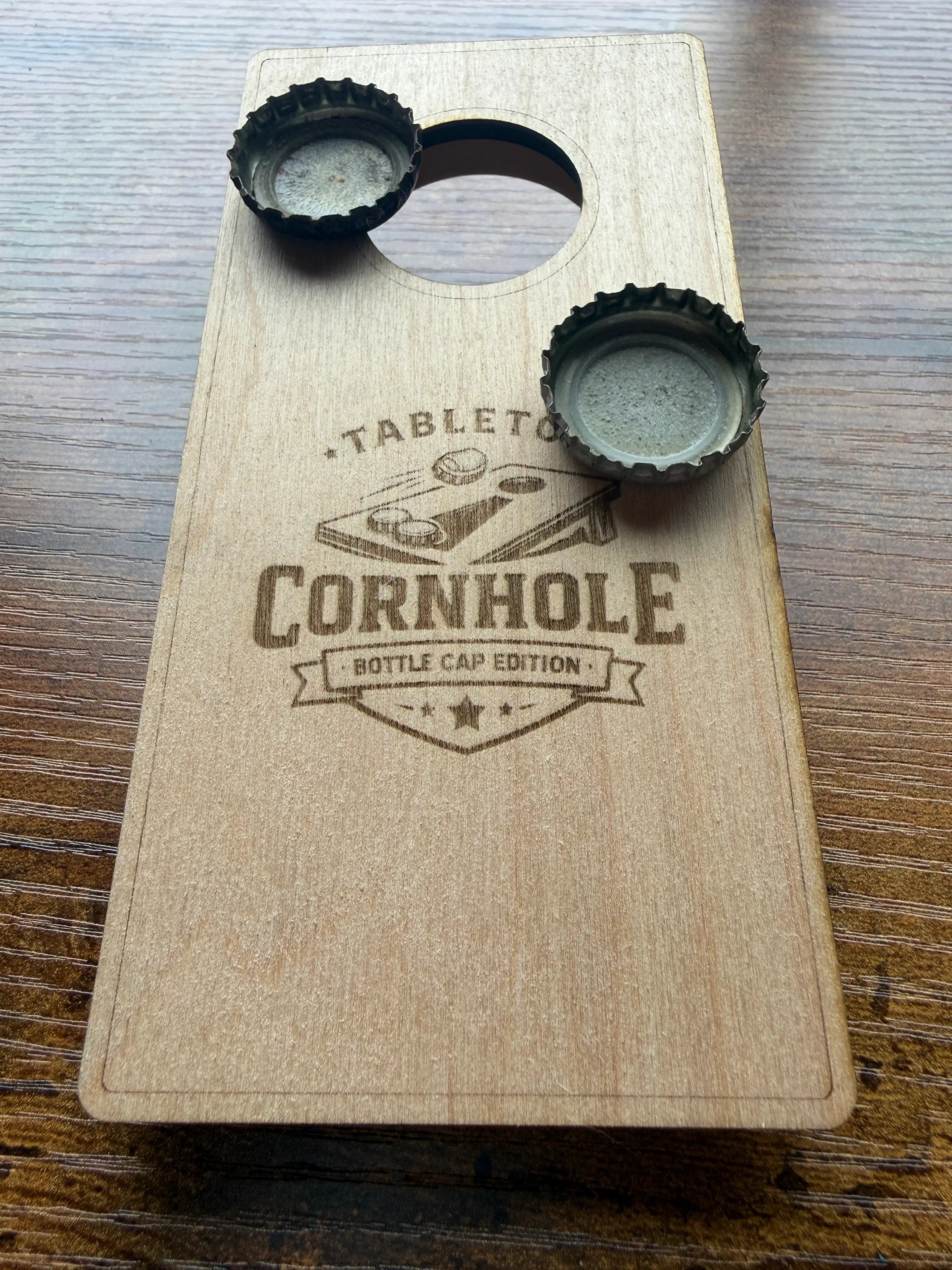 Wooden tabletop cornhole game, bottle cap edition, with engraved design and metal caps