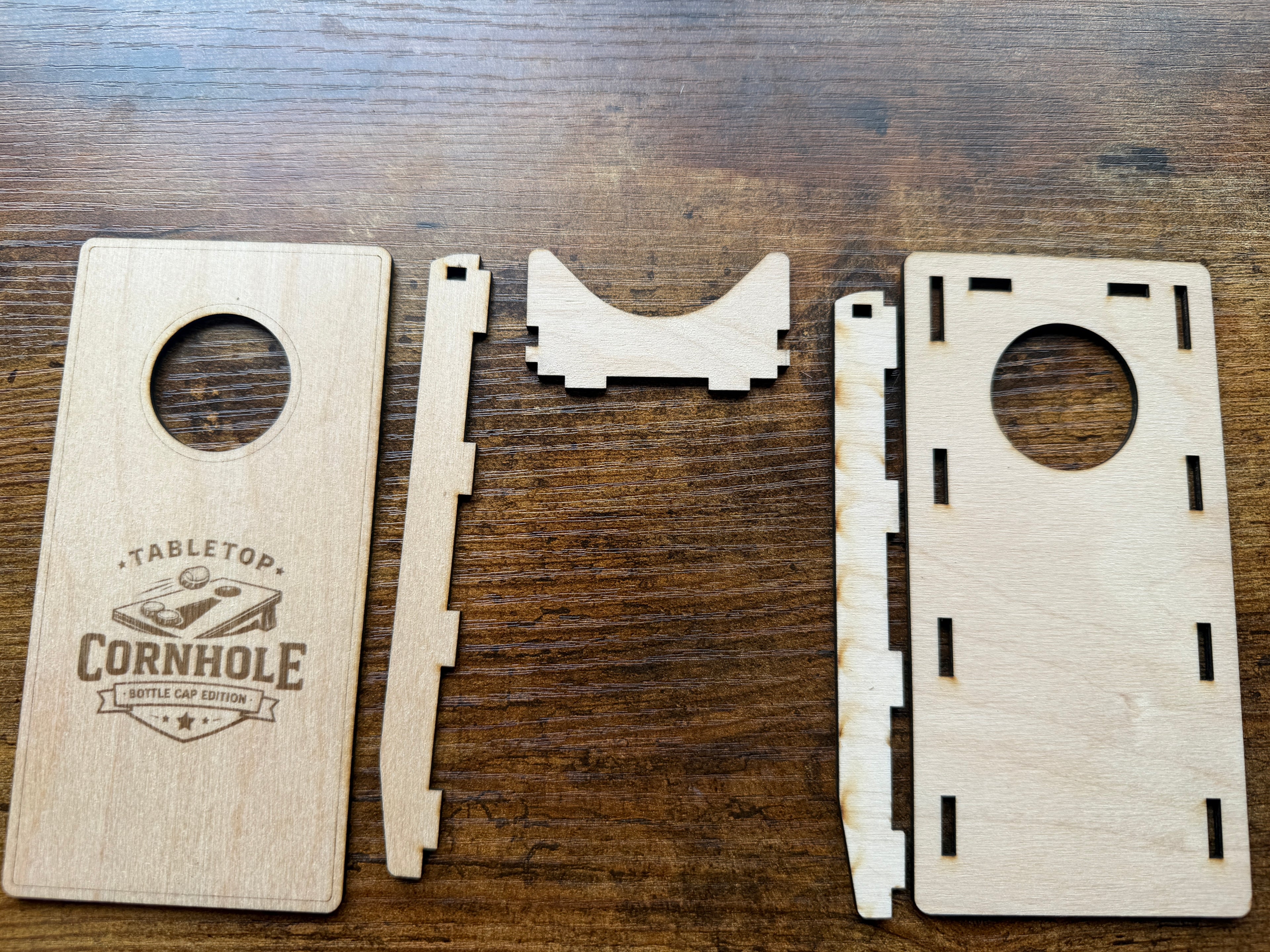 Tabletop cornhole game set with laser-cut wood pieces and bottle cap edition design