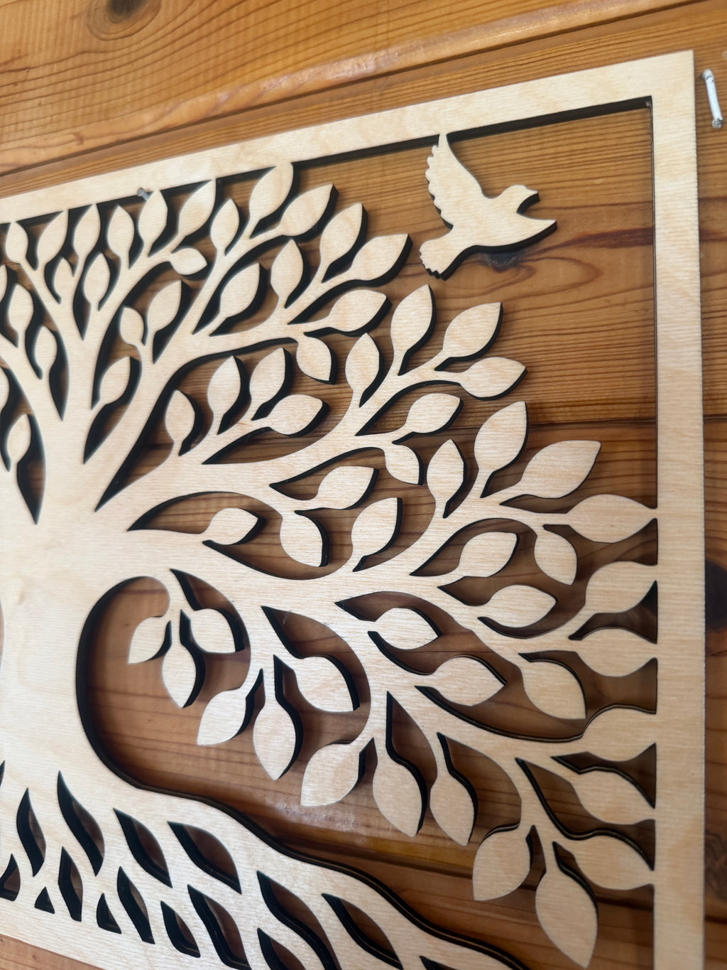 Layered wood art featuring a tree of life with a flying bird, handcrafted decor