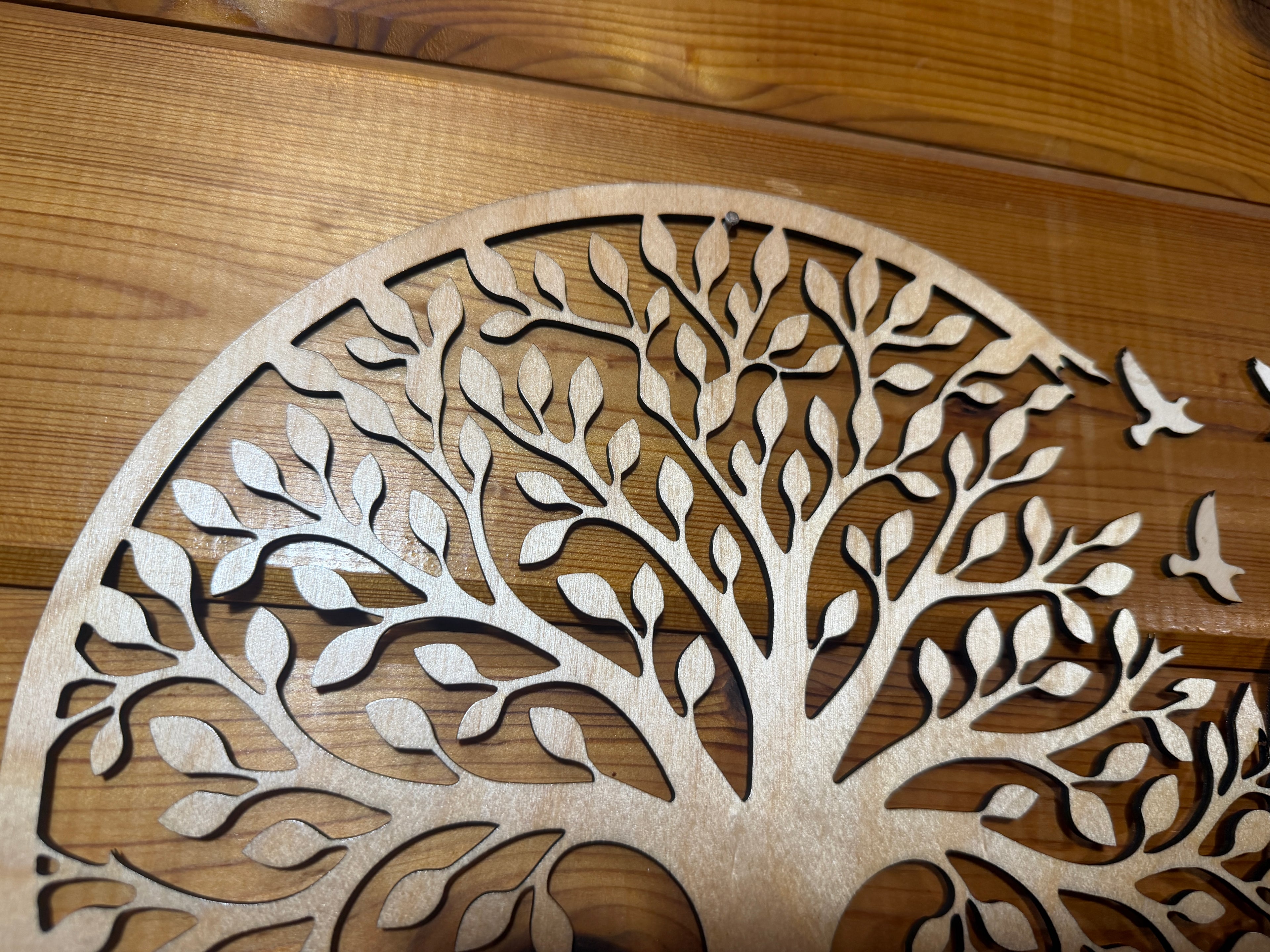 Laser-cut wooden tree of life wall art with intricate leaf and bird details