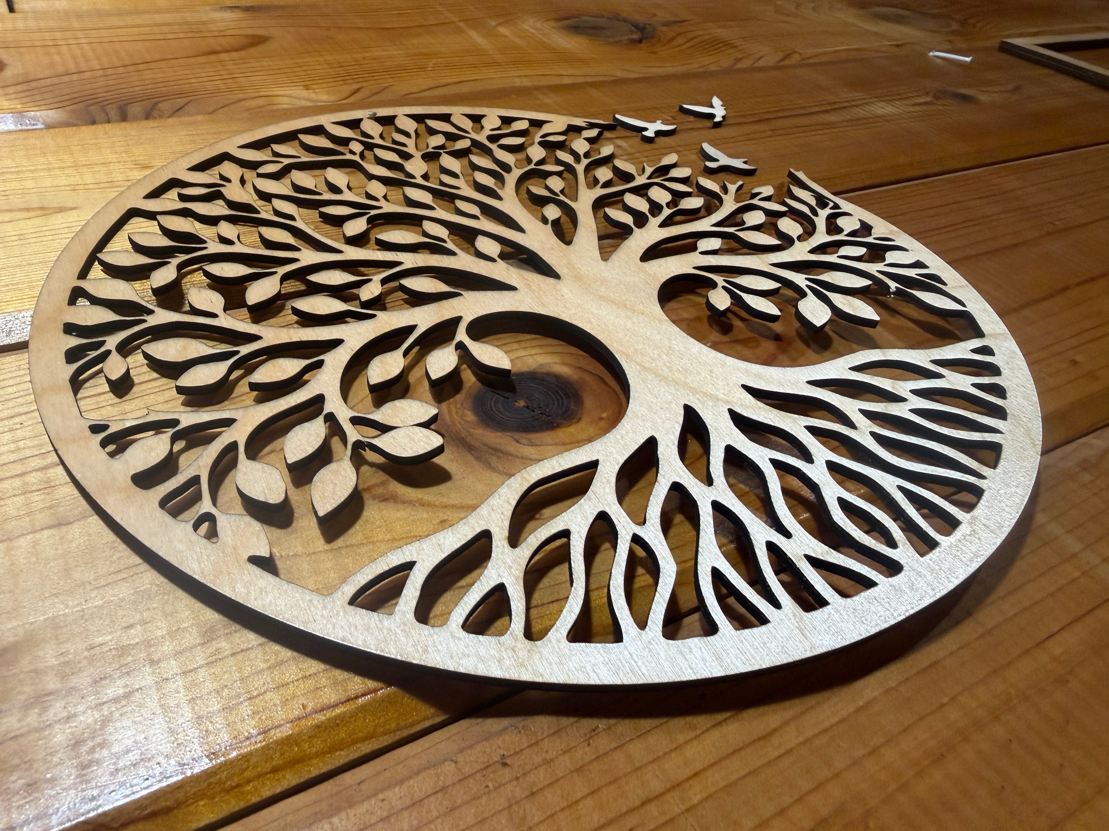 Laser-cut wooden tree of life wall art with intricate branches and roots, perfect for rustic decor.