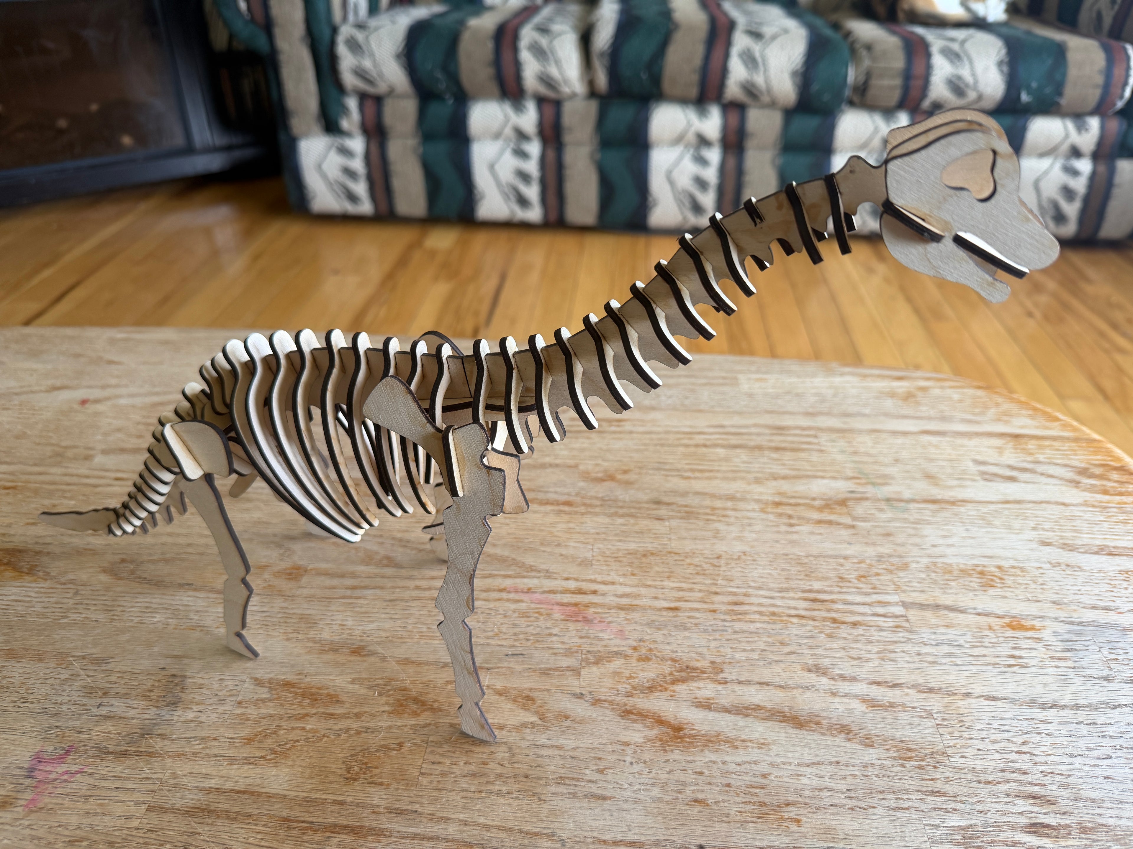 Handcrafted wooden dinosaur skeleton art, laser-cut layered design on rustic table.
