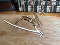 Laser-cut wooden dinosaur skeleton art piece on a rustic table, handcrafted decor