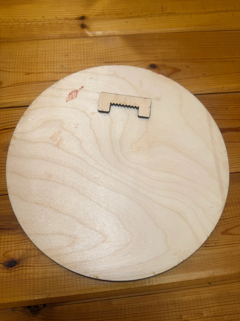 Laser-cut wood piece with sawtooth edge on round wooden base, handmade decor craft
