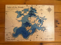 Layered wood map of Lake of the Woods, Canada and USA, with blue depth layers and compass rose