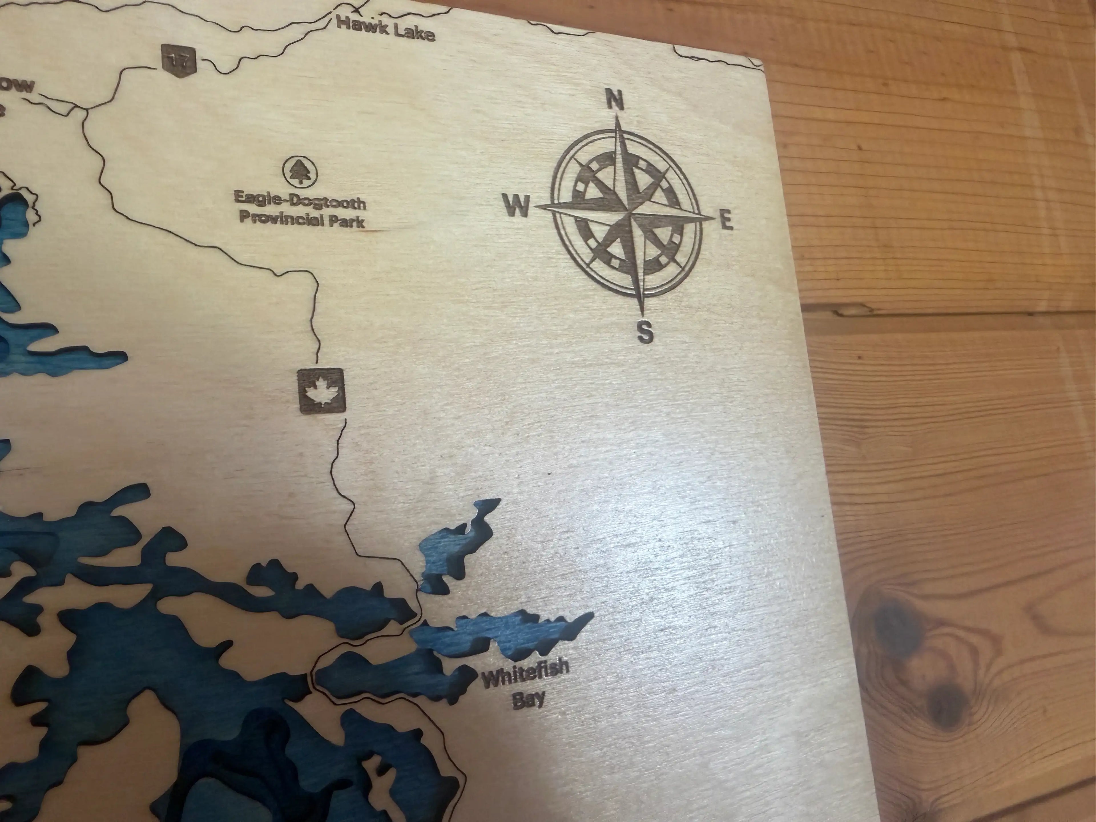 Layered wood lake map with compass, Hawk Lake and Whitefish Bay details, handcrafted decor