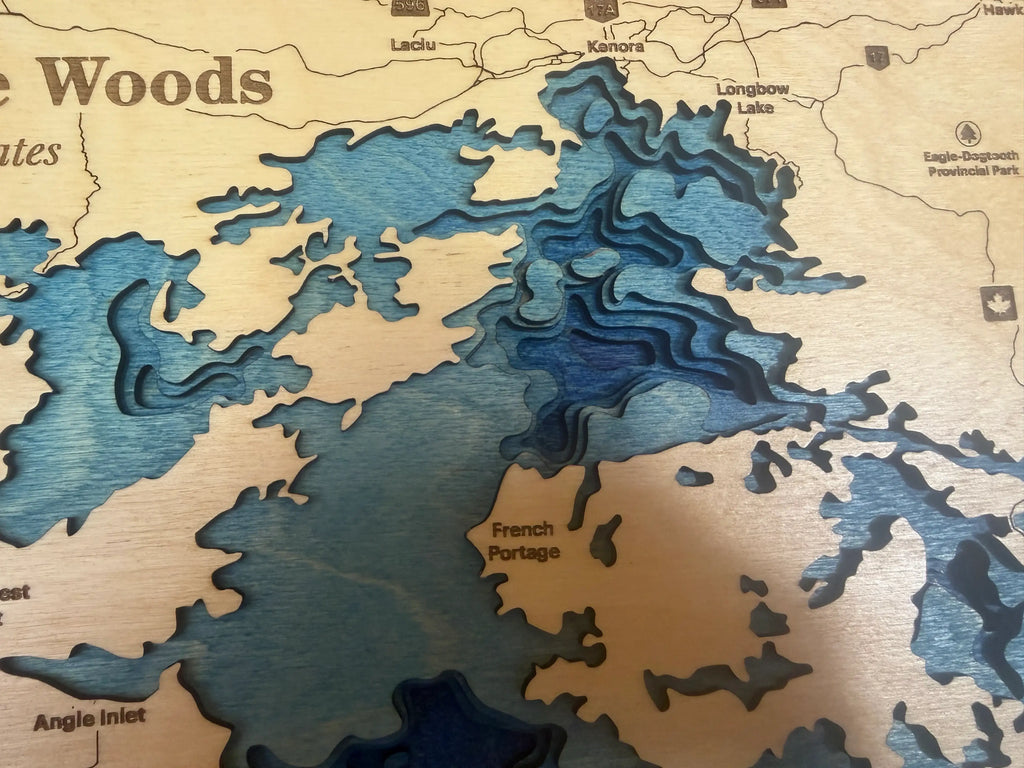 Layered wood lake map with blue depth contours and labeled locations like French Portage