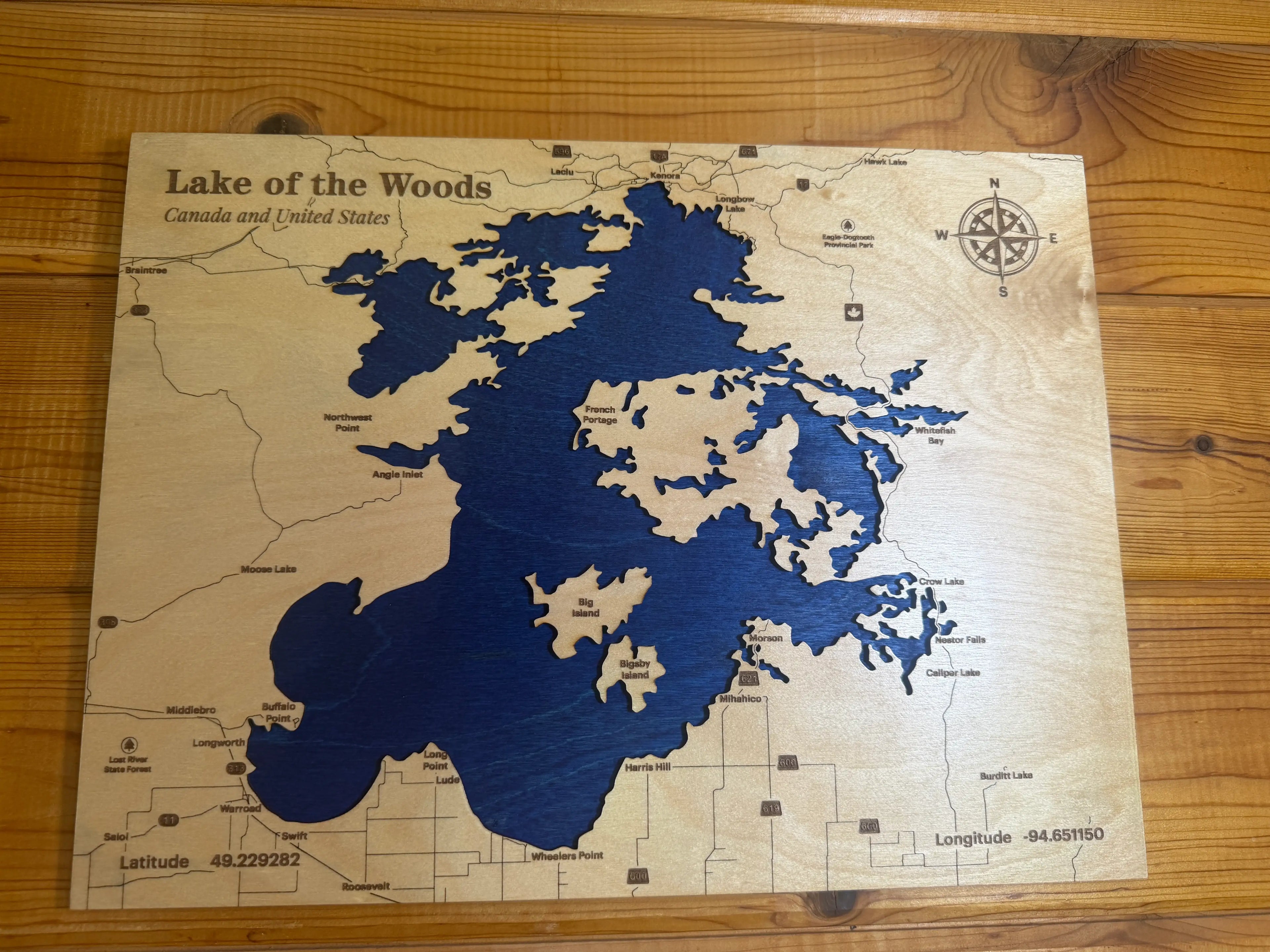 Handcrafted wooden map of Lake of the Woods, Canada and USA, featuring layered blue water and detailed landmarks.