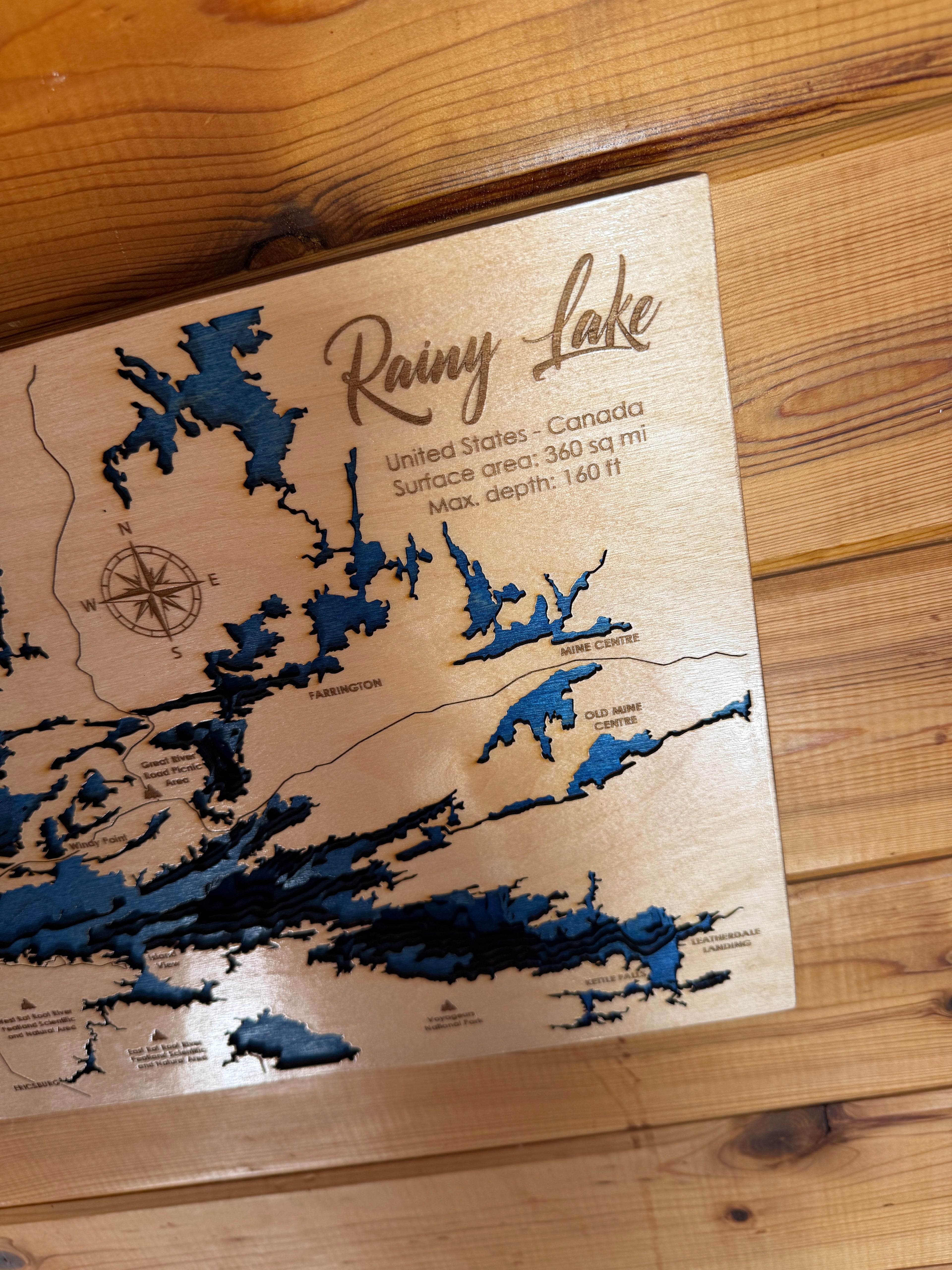 Wooden map of Rainy Lake on a wooden surface