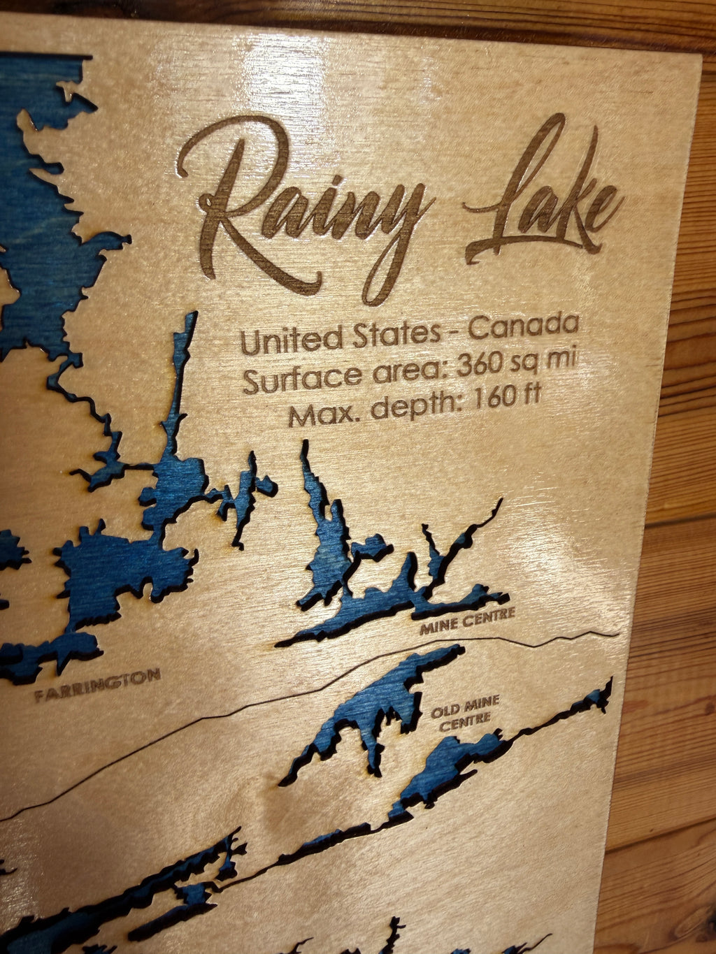 Wooden map of Rainy Lake with laser-cut details on a wooden surface