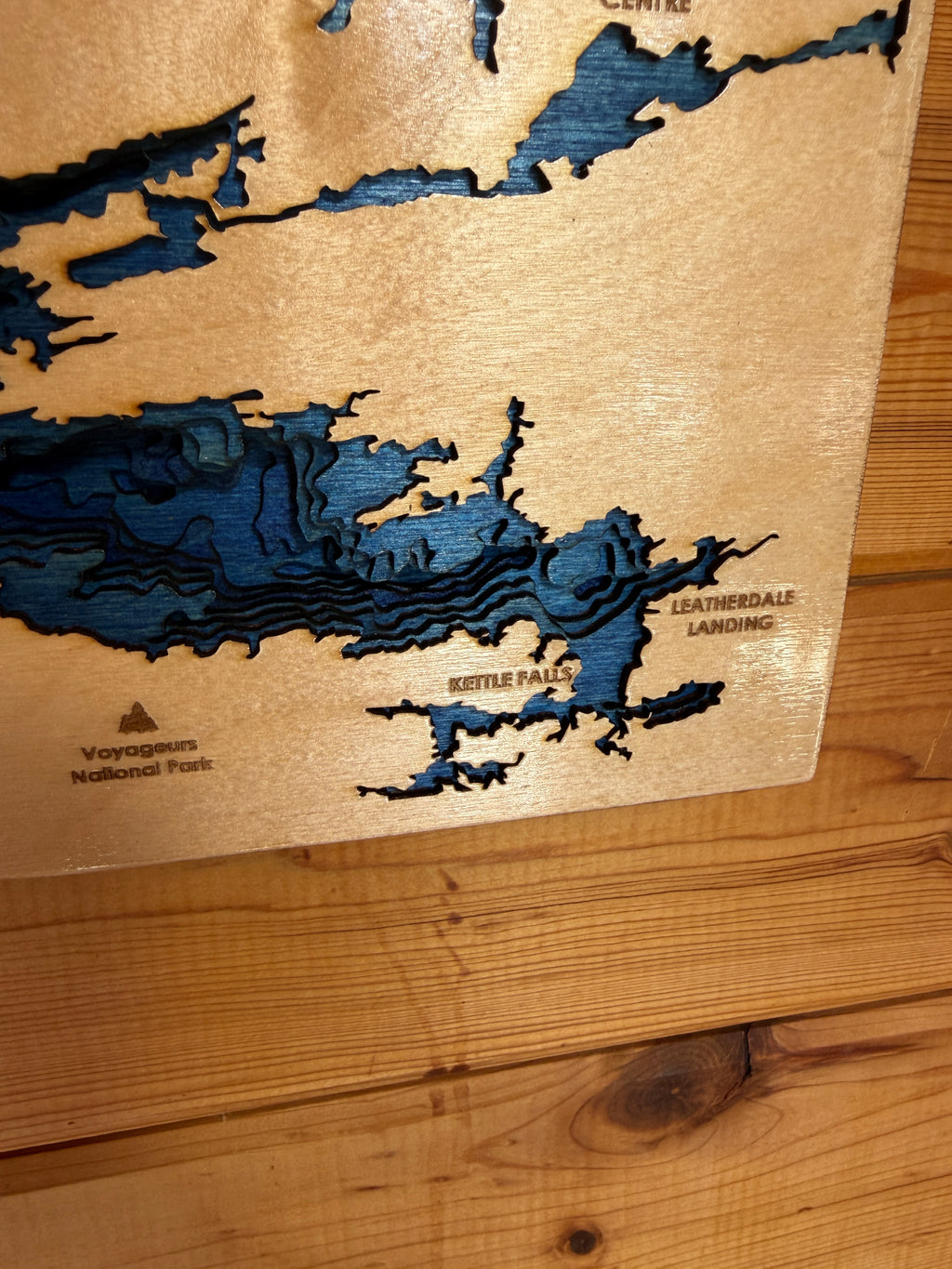 Wooden map with blue cut-out details on a wooden surface