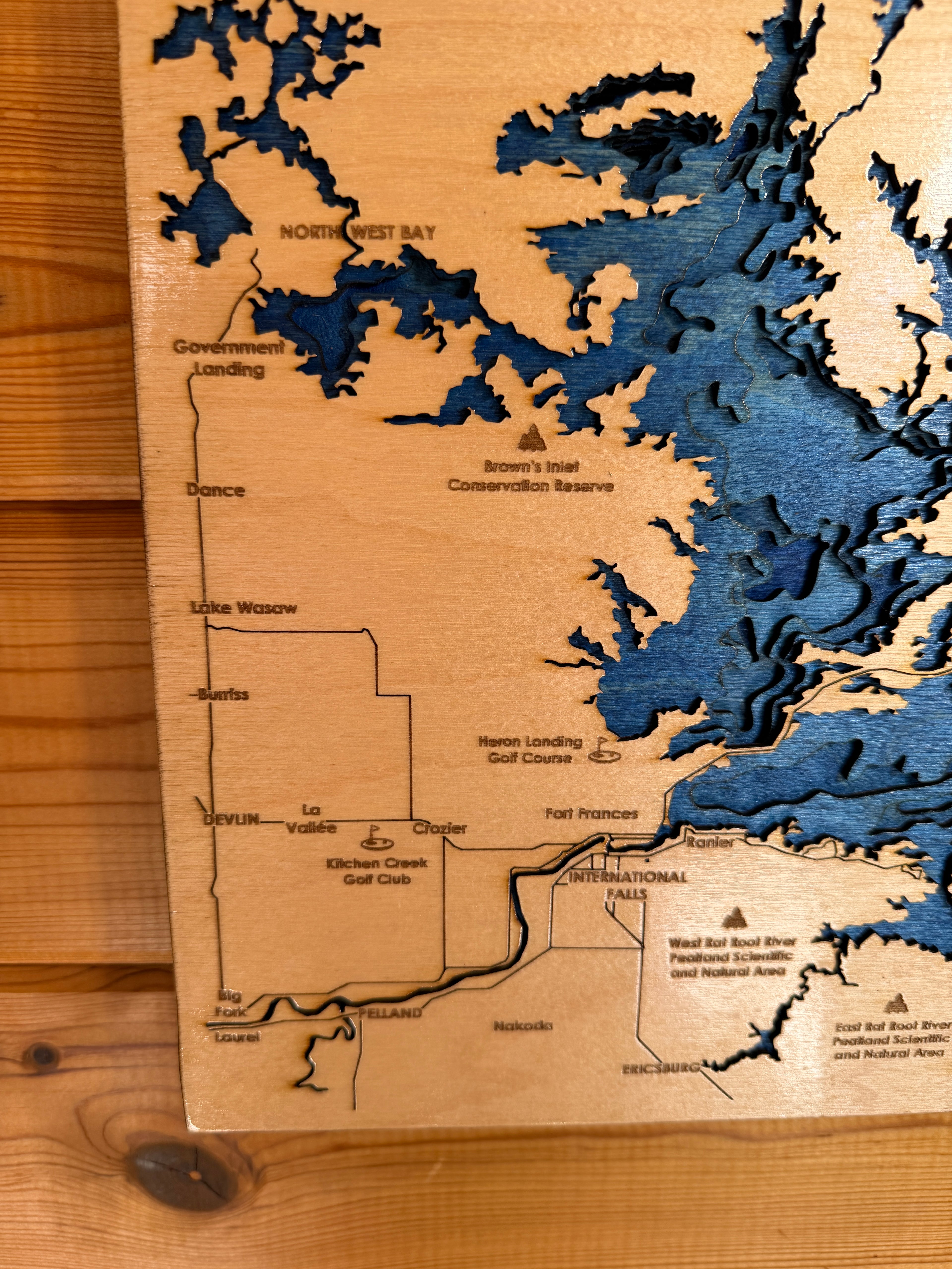 Wooden map with topographic details of a lake on a wooden surface