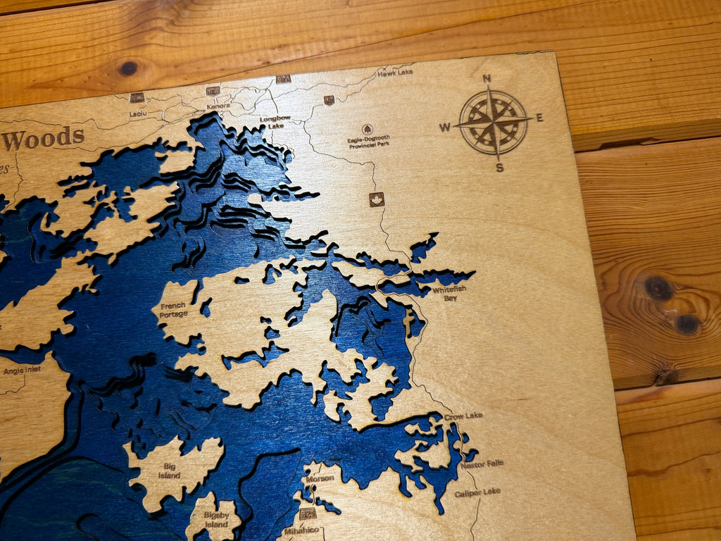 Handcrafted layered wood lake map with blue depth layers, compass rose, and place names, perfect rustic wall art.