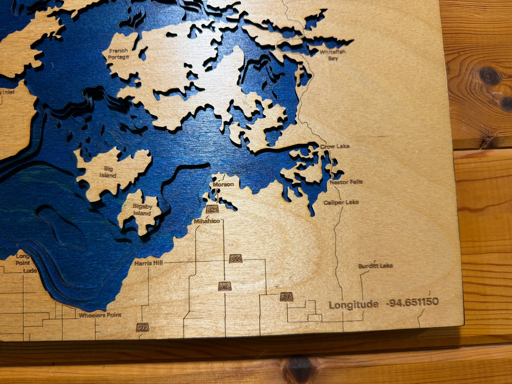 Layered wood lake map with blue water depths, islands, and locations like Big Island and Crow Lake, handcrafted decor.