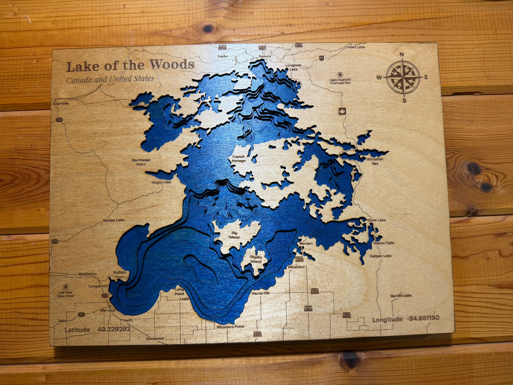 Layered wood map of Lake of the Woods, Canada & USA, with blue depth layers and engraved details, handcrafted decor.