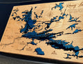 Layered wood map of Rainy Lake with blue water depths, laser-cut details, and engraved landmarks for rustic home decor.