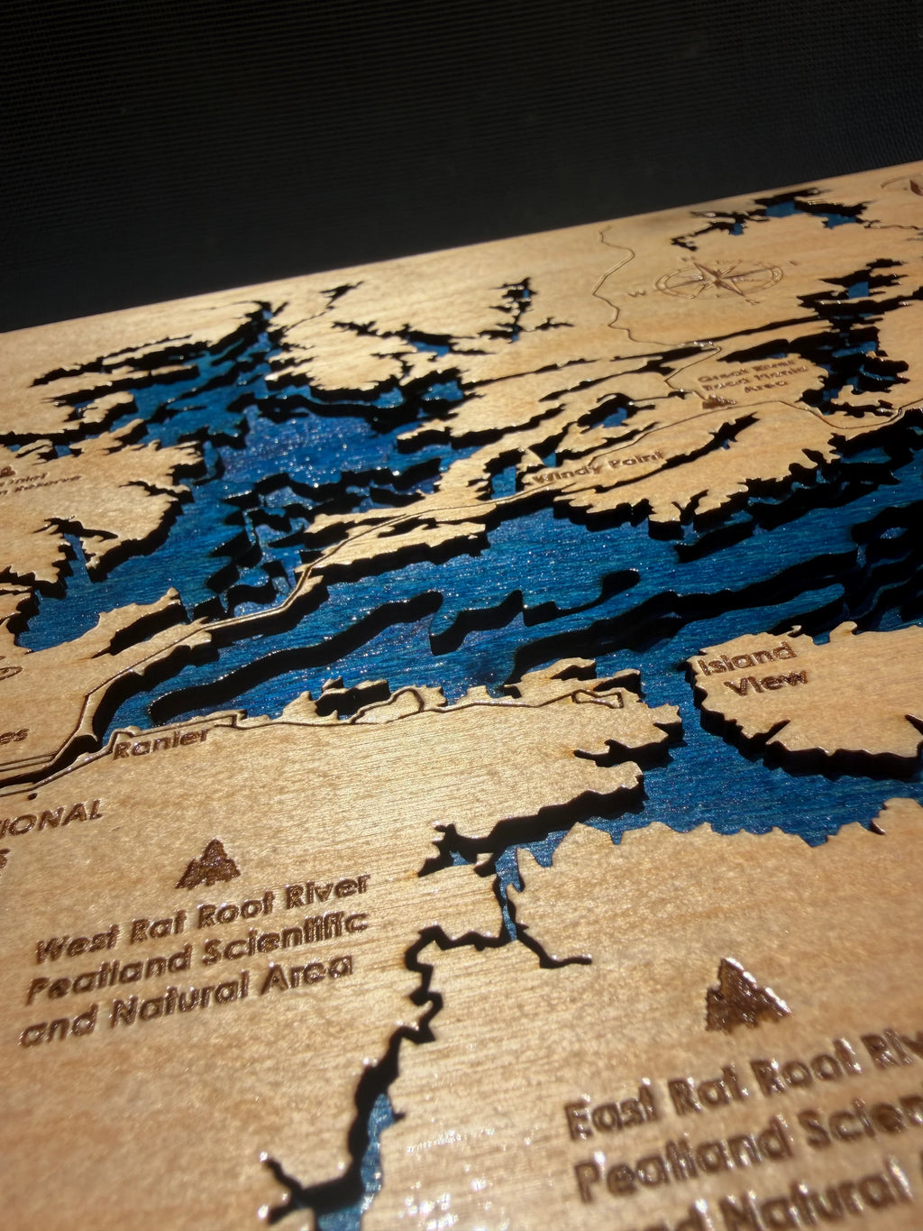 Handcrafted layered wood lake map with blue water details, laser-cut for rustic home decor.