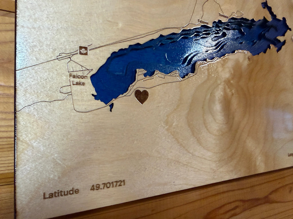 Handcrafted layered wood map of Falcon Lake with blue resin water, heart accent, and engraved latitude, custom laser-cut decor.