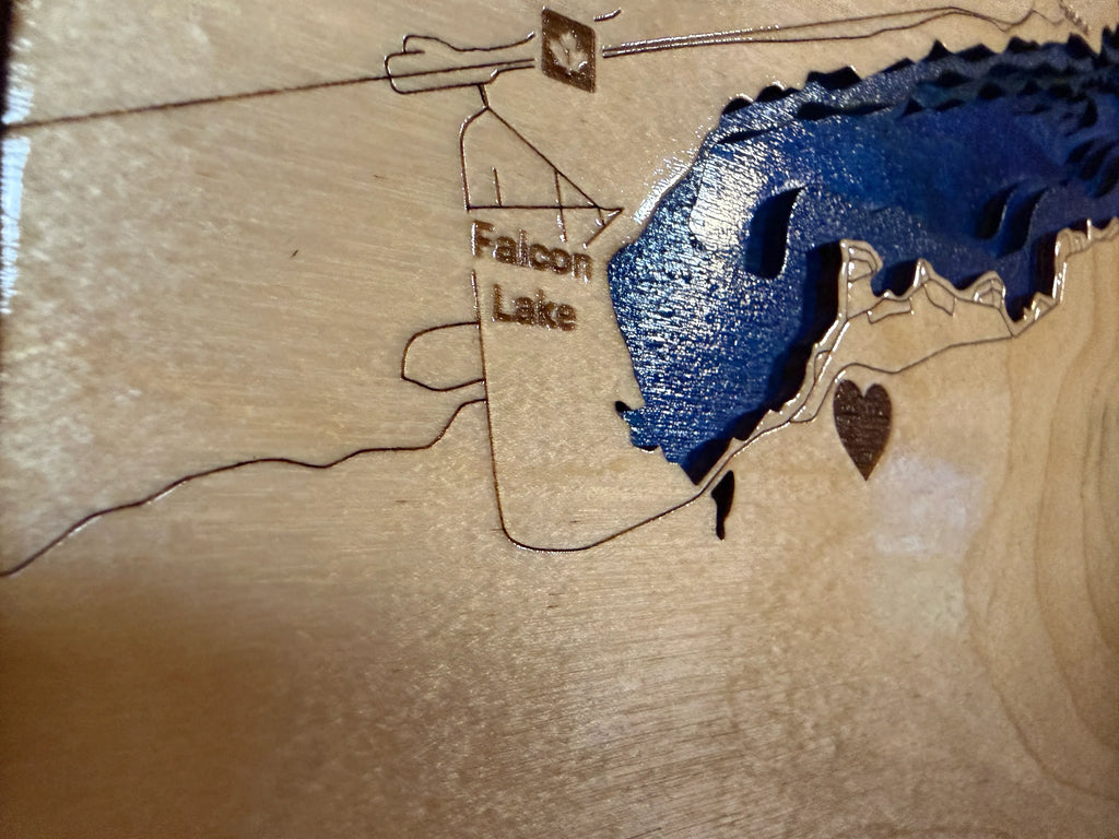 Laser-cut wooden map of Falcon Lake with blue resin water, heart accent, and rustic cabin detail.