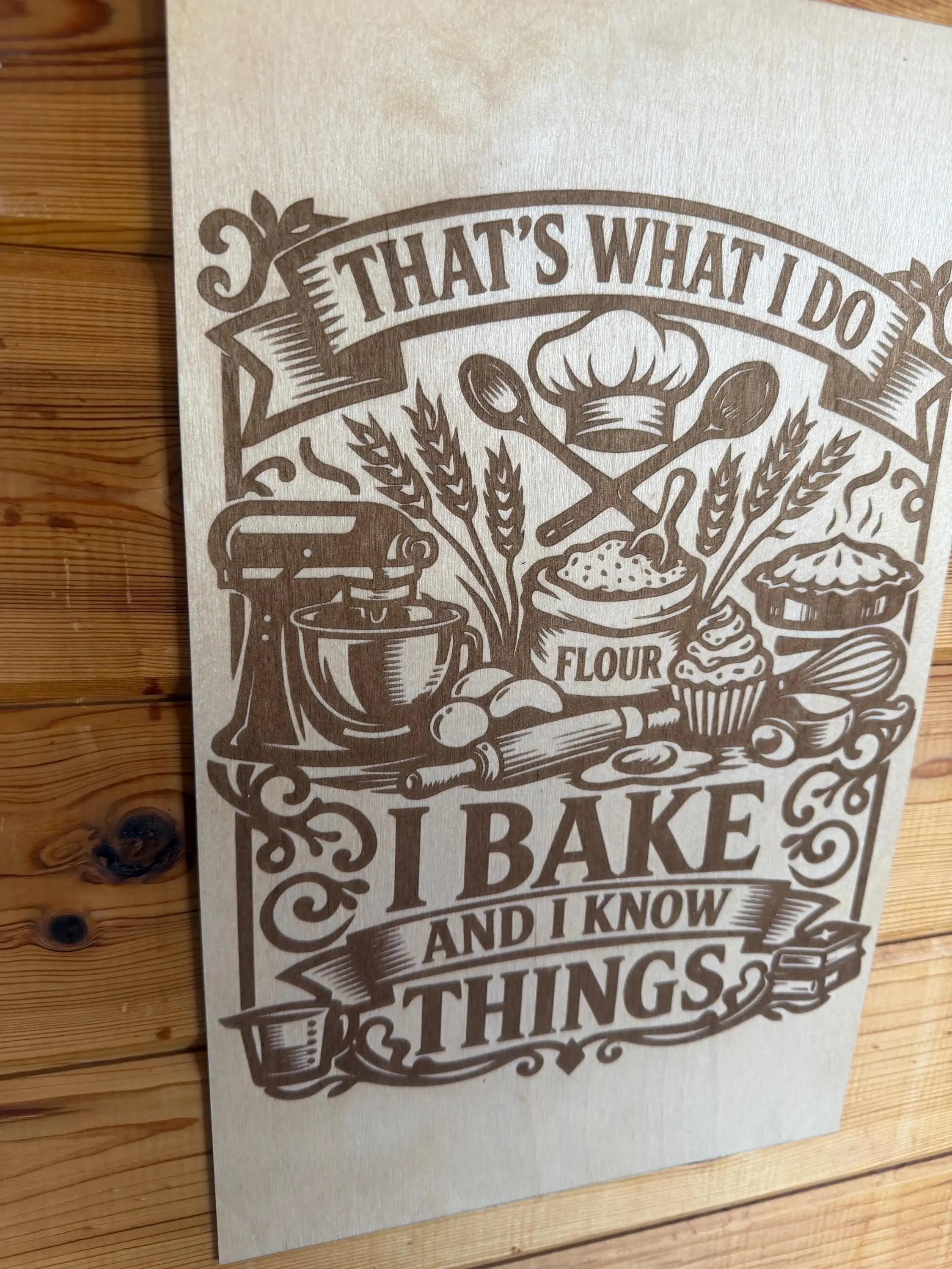 Laser-cut wood art with 'I bake and I know things' quote, featuring baking tools and flour sack design