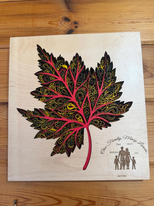 Custom layered wood art maple leaf with intricate patterns and family names, handcrafted decor