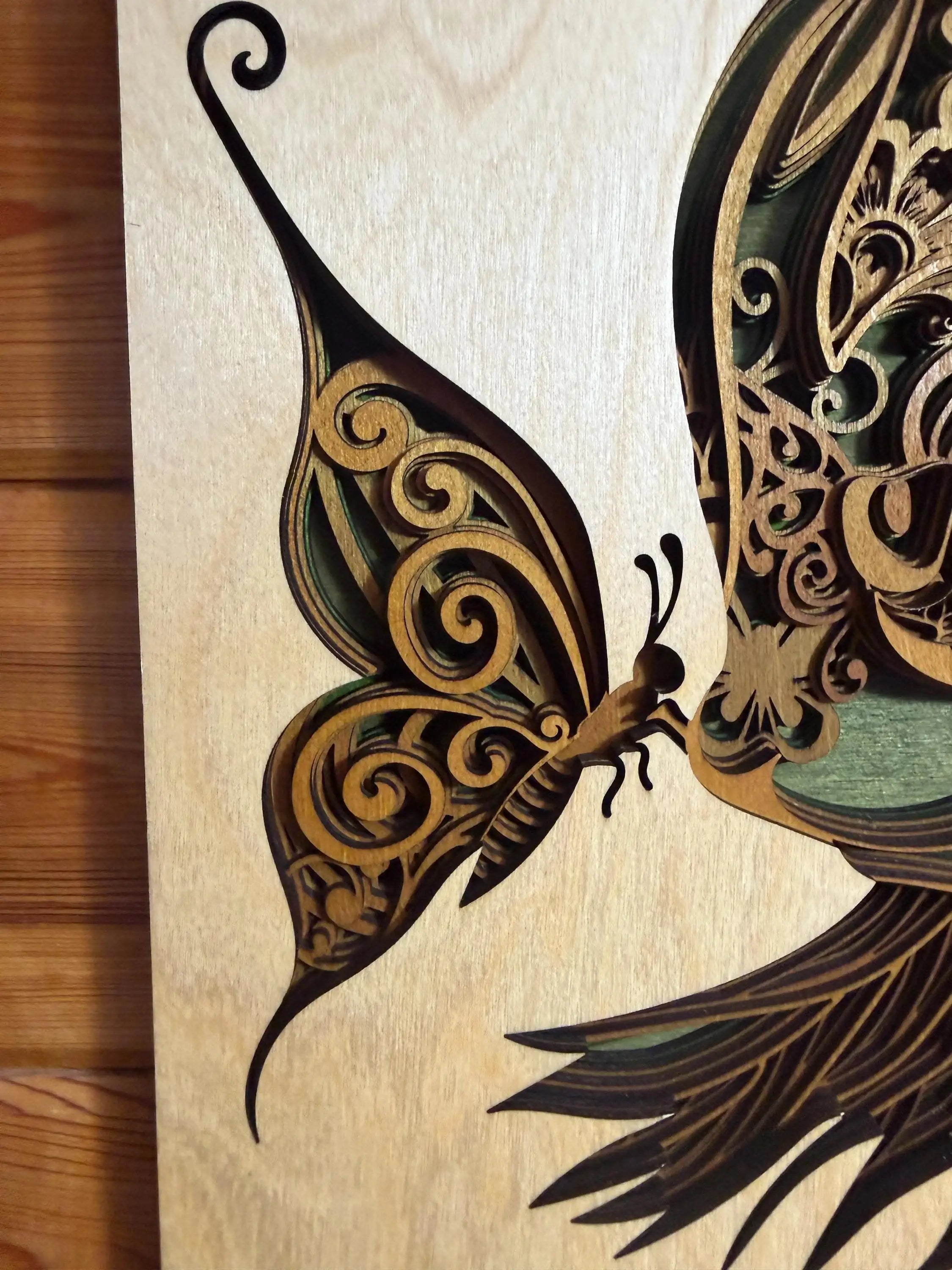 Intricate laser-cut wooden butterfly art with swirling patterns and layered details