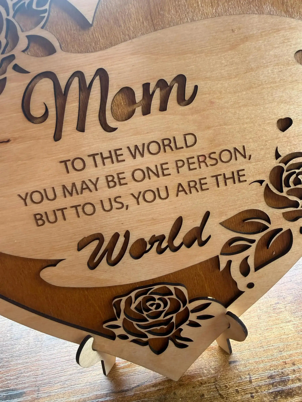 Laser-cut wooden sign with 'Mom' and heartfelt message, adorned with rose designs for home decor.