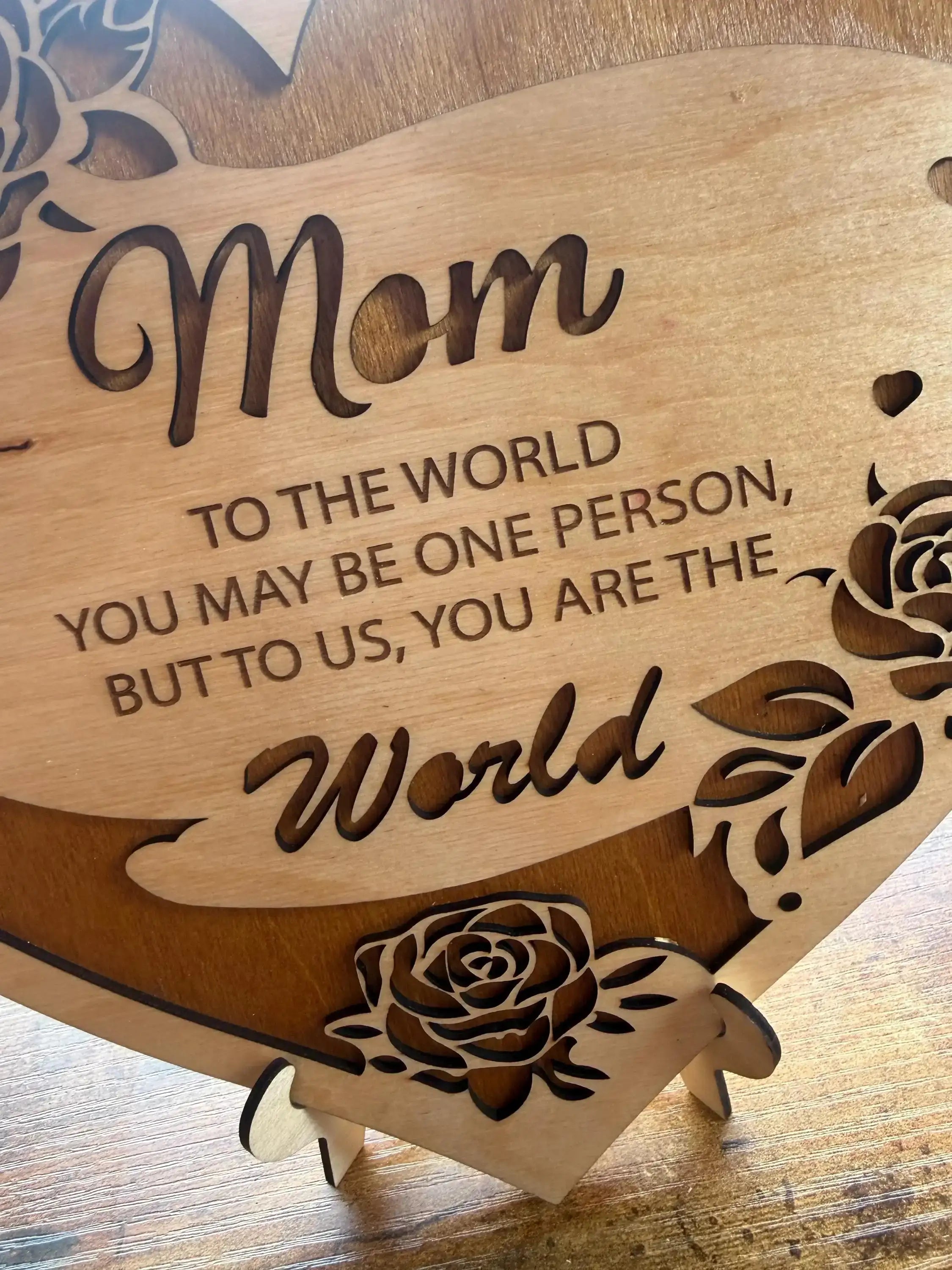 Laser-cut wooden sign with 'Mom' and heartfelt message, adorned with rose designs for home decor.