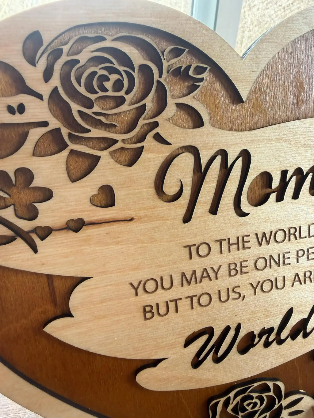 Handcrafted wooden sign with rose design and heartfelt 'Mom' message, laser-cut for unique decor.