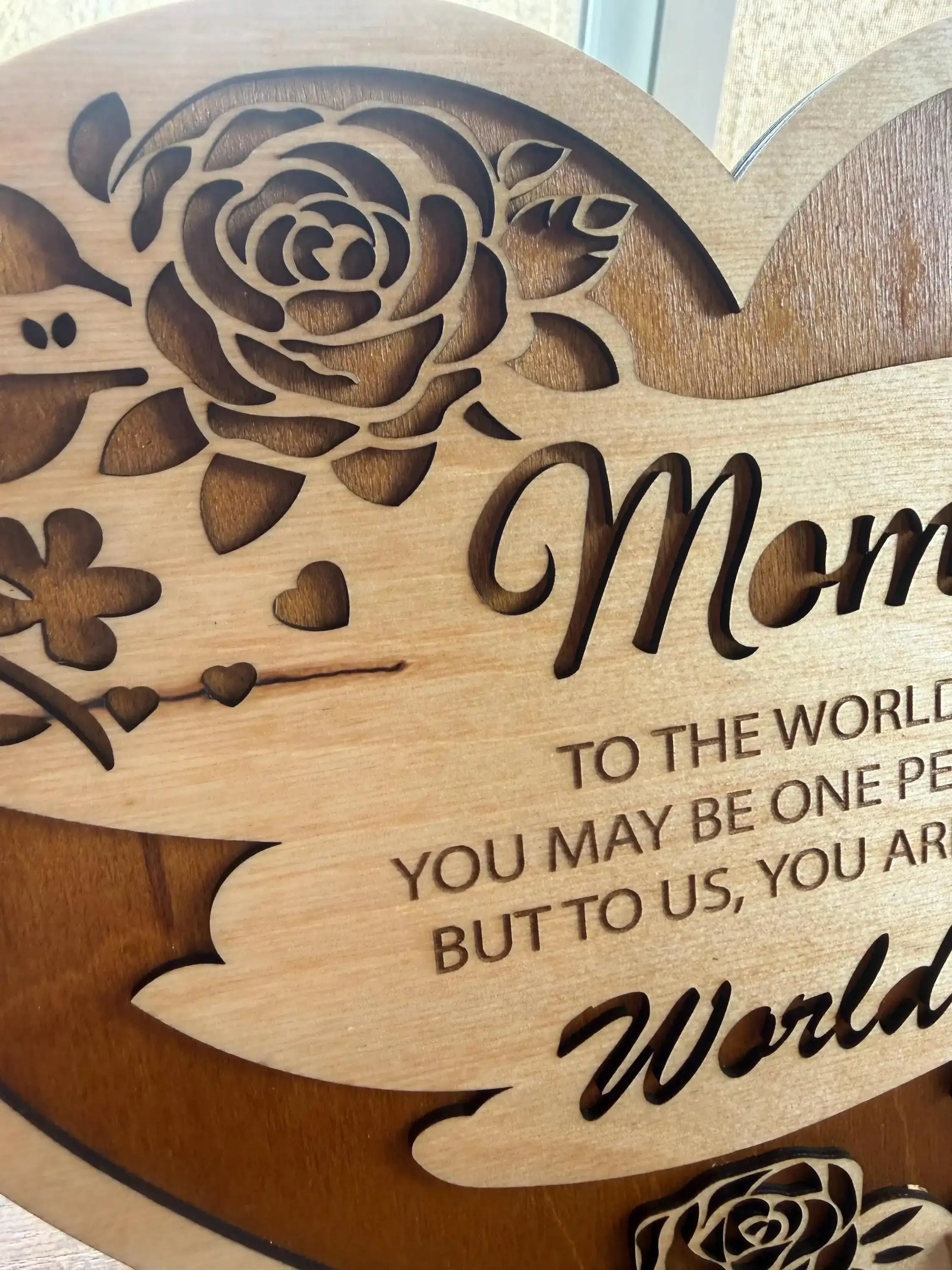 Handcrafted wooden sign with rose design and heartfelt 'Mom' message, laser-cut for unique decor.