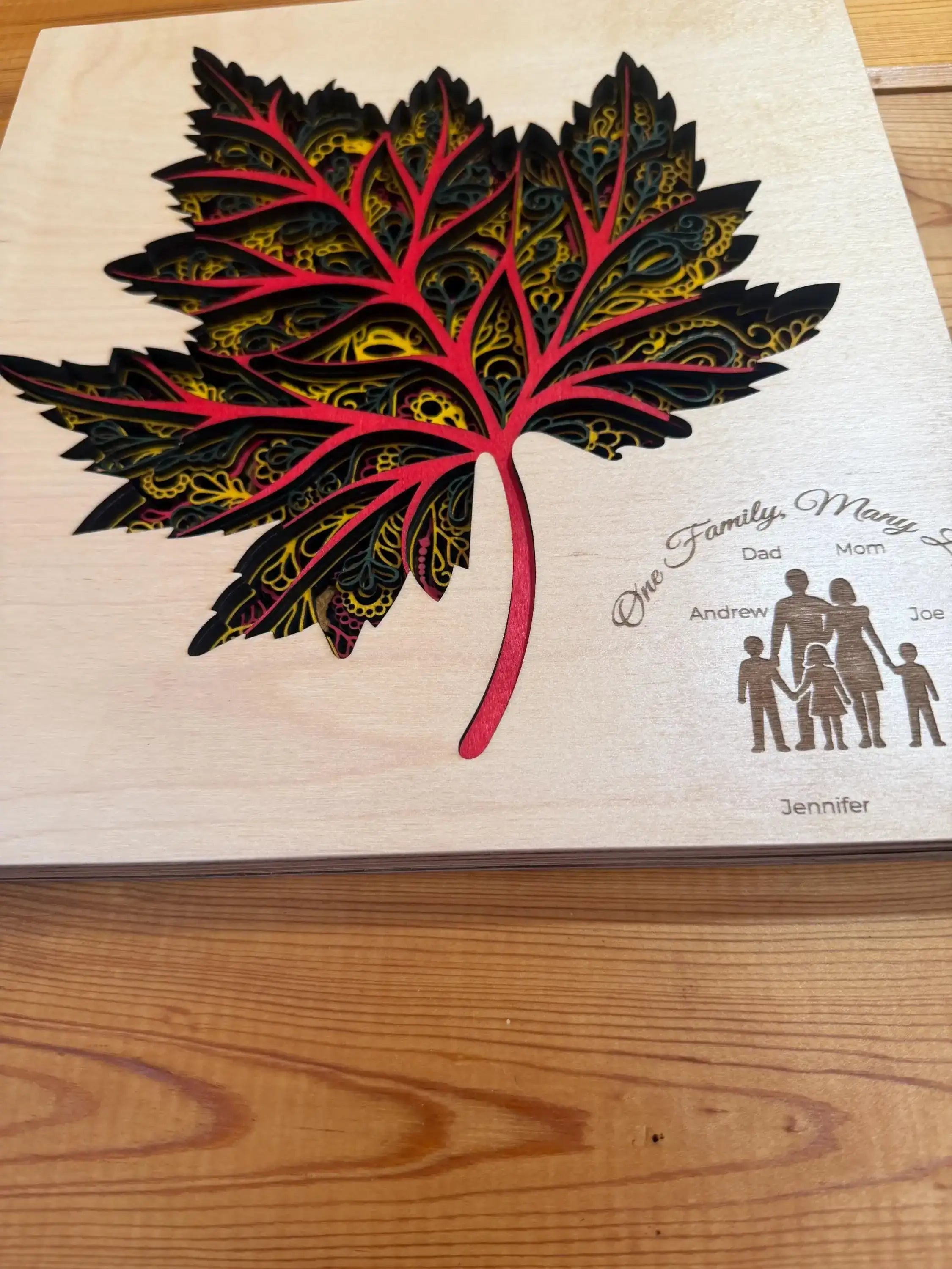 Layered wood art maple leaf with family silhouettes, custom laser-cut decor
