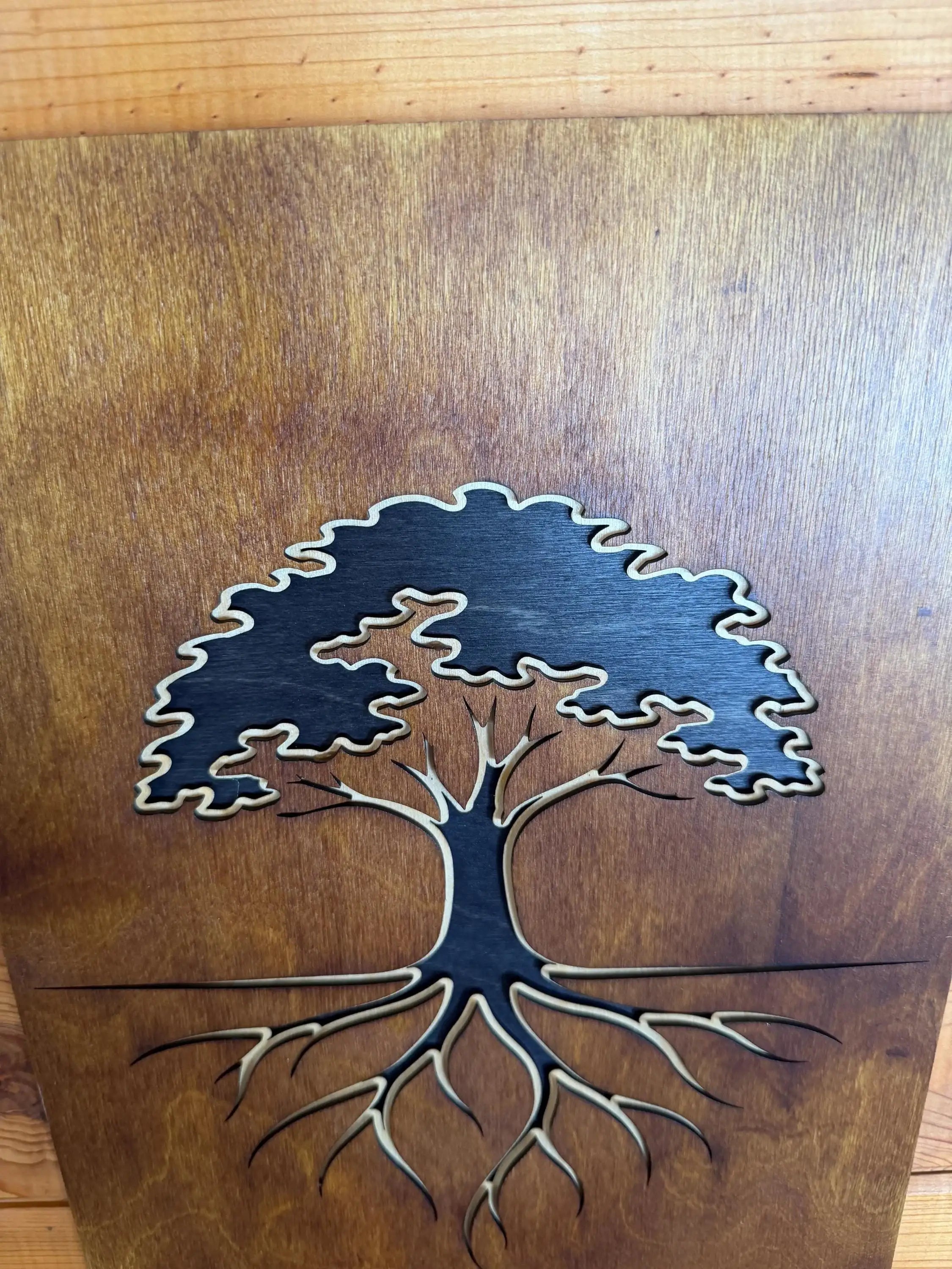 Layered wood art of a tree with roots, handcrafted laser-cut wall decor