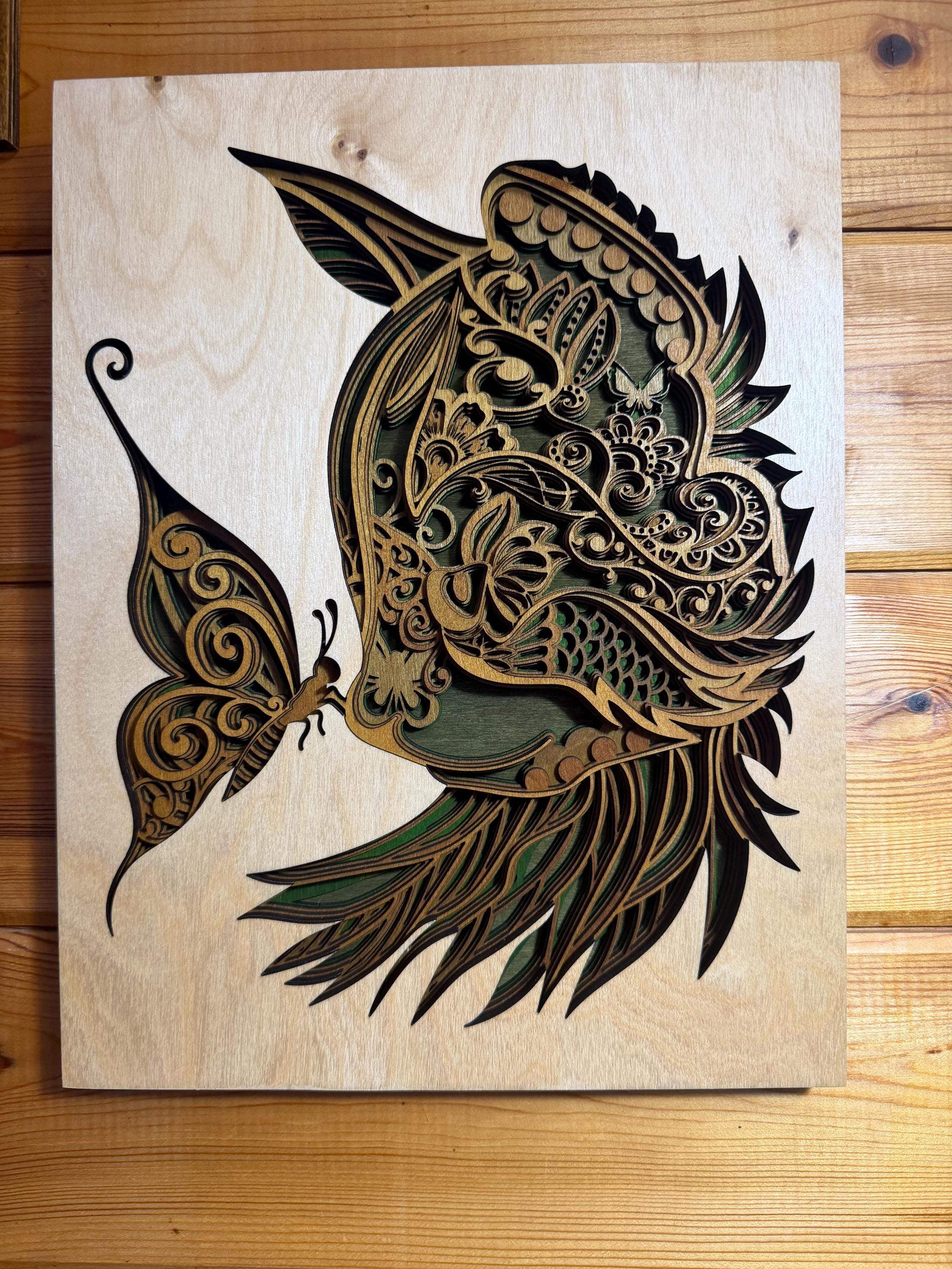 Layered wood art of a hummingbird and butterfly, handcrafted laser-cut wall decor with intricate mandala details.